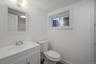 Bathroom with vanity, toilet, and baseboards