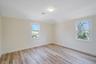Spare room featuring healthy amount of natural light, light wood finished floors, and baseboards