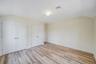Unfurnished bedroom with multiple closets, vaulted ceiling, light wood-style flooring, and baseboards