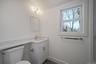 Bathroom with toilet, vanity, and baseboards