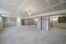 Basement with electric panel, heating unit, and healthy amount of natural light