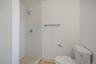 Bathroom with toilet, a tile shower, and wood finished floors