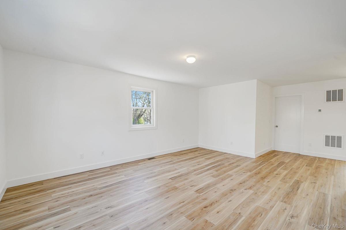 Empty room with light wood-type flooring and baseboards