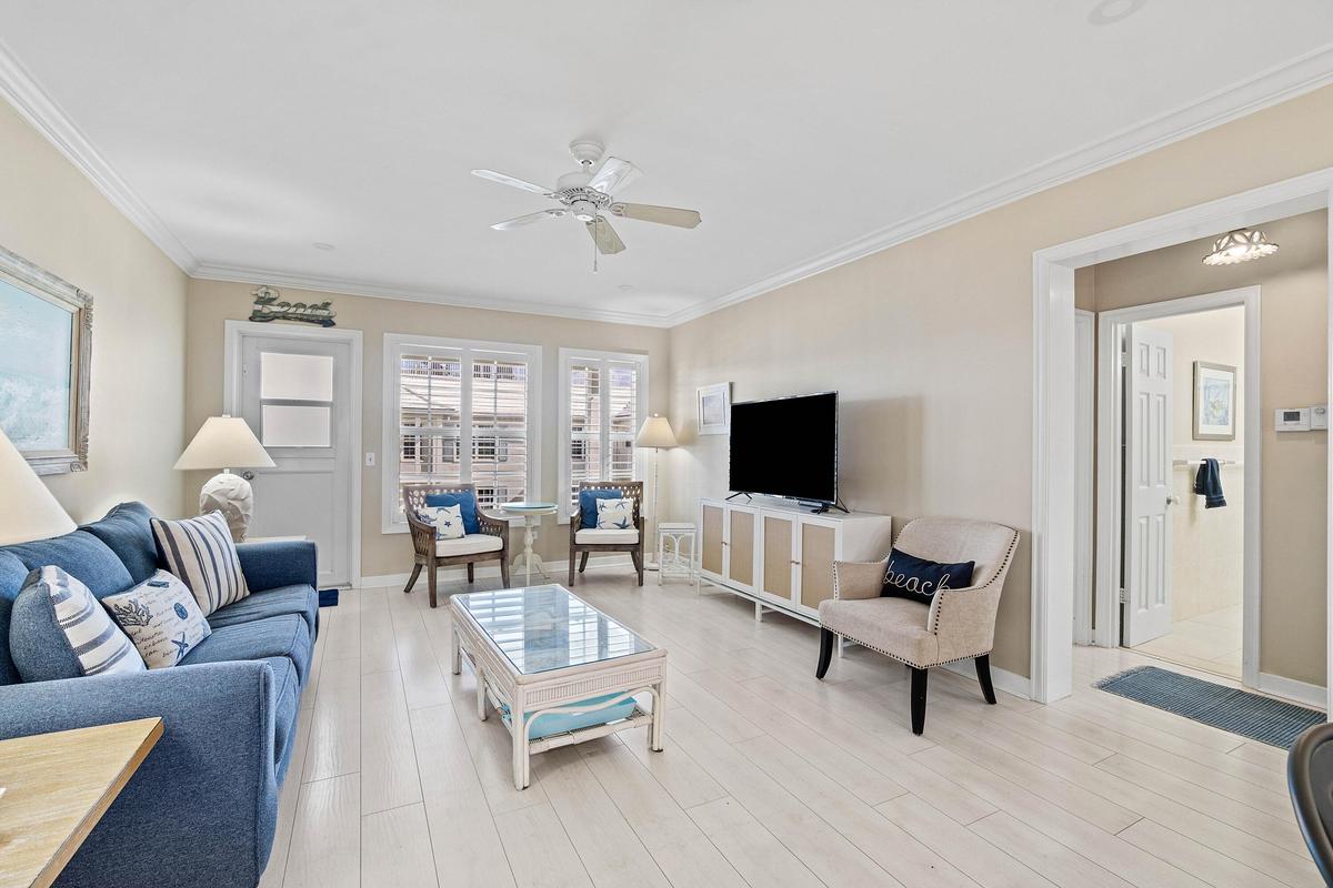 Light wood-finish flooring, crown molding, and a ceiling fan