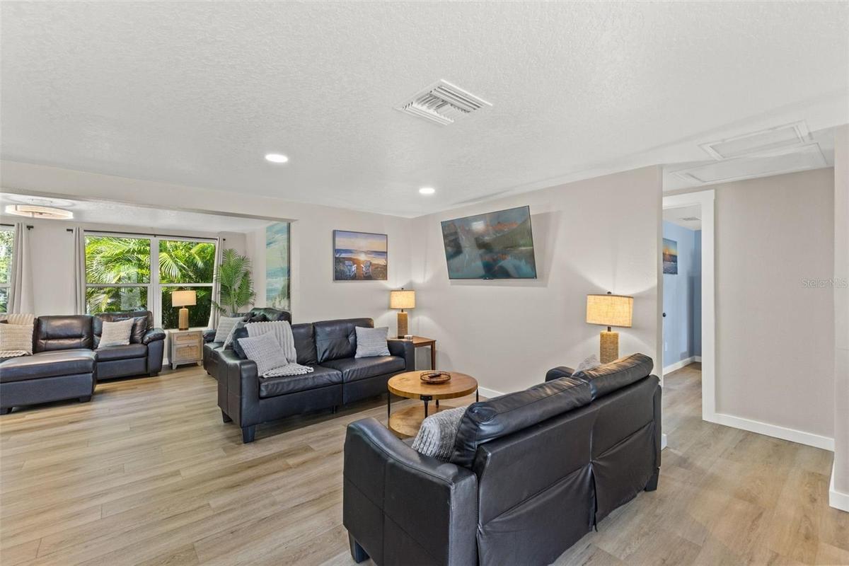 Spacious living area with luxury vinyl plank flooring, abundant natural light, and an open layout.