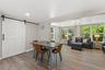 Dedicated dining area sits between the renovated kitchen and living spaces, with a large barn door adding character and function.