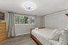 Spacious third bedroom with LVP flooring, modern ceiling fan, and flexible space for guests, a home office, or both.
