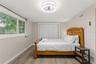 Bright secondary bedroom with luxury vinyl plank flooring, a large window, and ample closet storage.