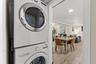 Convenient interior laundry with a full-size stacked washer and dryer just off the main living and dining areas.