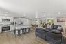 The renovated kitchen opens to the main living areas and features new cabinetry, granite countertops, stainless steel appliances, and a large gatherin