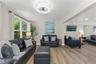 Large windows bring natural light and tropical views into this spacious living area.