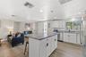 Generous granite-topped island adds abundant prep space, storage, and casual seating to the renovated kitchen.
