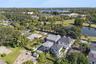 An aerial view shows the home and surrounding neighborhood, with the golf course and pond across the street.