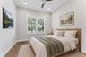 Virtually Staged - A shuttered window, ceiling fan, and light walls create a bright bedroom setting.