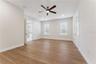 A second view of the primary bedroom shows its windows and open floor space.