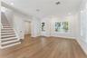 The front room offers natural light, recessed lighting, and a view of the staircase.