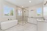A freestanding tub, glass-enclosed shower, and two sinks define this spacious bathroom.