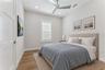 Virtually Staged - This bedroom features a white ceiling fan, shuttered window, and light finishes.