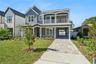A driveway-side view shows the home's front porch, balcony, and covered side passage.