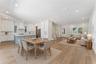 Virtually Staged - An open living area connects to the kitchen, with a blue island and coordinated white cabinetry.