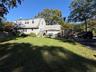 Back of home, partial view of yard,  from driveway
