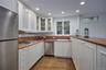 Kitchen with wooden counters, appliances with stainless steel finishes, recessed lighting, dark wood-style floors, and white cabinets