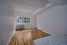 Unfurnished bedroom with beamed ceiling, hardwood / wood-style floors, and radiator heating unit