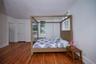 Bedroom with wood finished floors and radiator heating unit