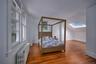 Bedroom with radiator heating unit, hardwood / wood-style floors, vaulted ceiling, and a skylight