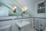 Half bath featuring radiator heating unit, tile walls, tile patterned floors, and lofted ceiling