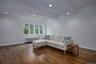 Living area featuring radiator heating unit, dark wood-style floors, and recessed lighting