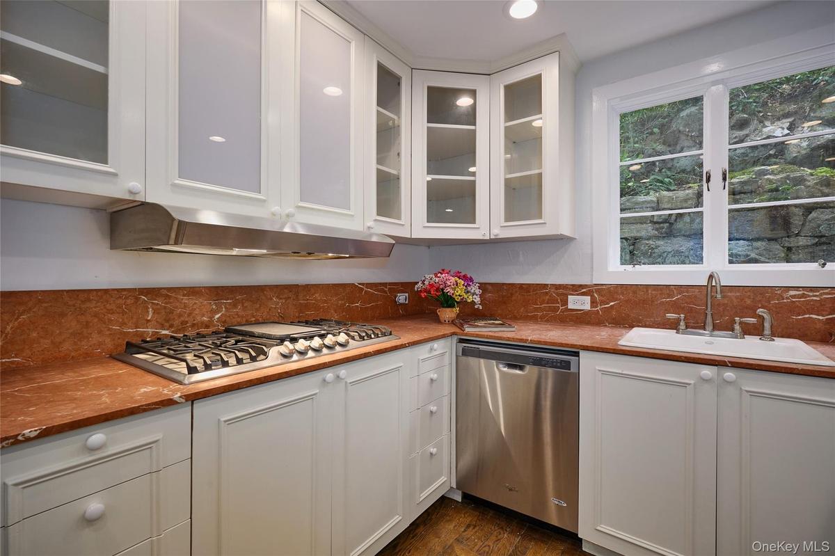 Kitchen with white cabinetry, stainless steel appliances, glass insert cabinets, and recessed lighting