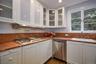 Kitchen with white cabinetry, stainless steel appliances, glass insert cabinets, and recessed lighting