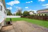 The backyard patio is located off the rear corner of the house and the stairs down to the outside entrance of the basement.