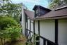 View of side of property with a shingled roof and a chimney