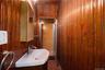 Bathroom featuring vanity, wooden walls, and dark wood finished floors