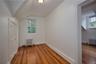 Additional living space featuring hardwood / wood-style floors, radiator heating unit, and lofted ceiling