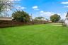 View of the backyard with an established lawn that is professionally landscaped.