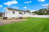 Here is a view of the backyard, looking towards the rear of the home and the side access porch off the kitchen.