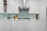 Gas cooktop, exhaust hood and custom depth counter tops to allow for more prep space