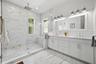 Huge primary bath with double sinks, an oversized shower and plenty of natural light