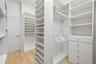 Primary walk in closet with custom shelving
