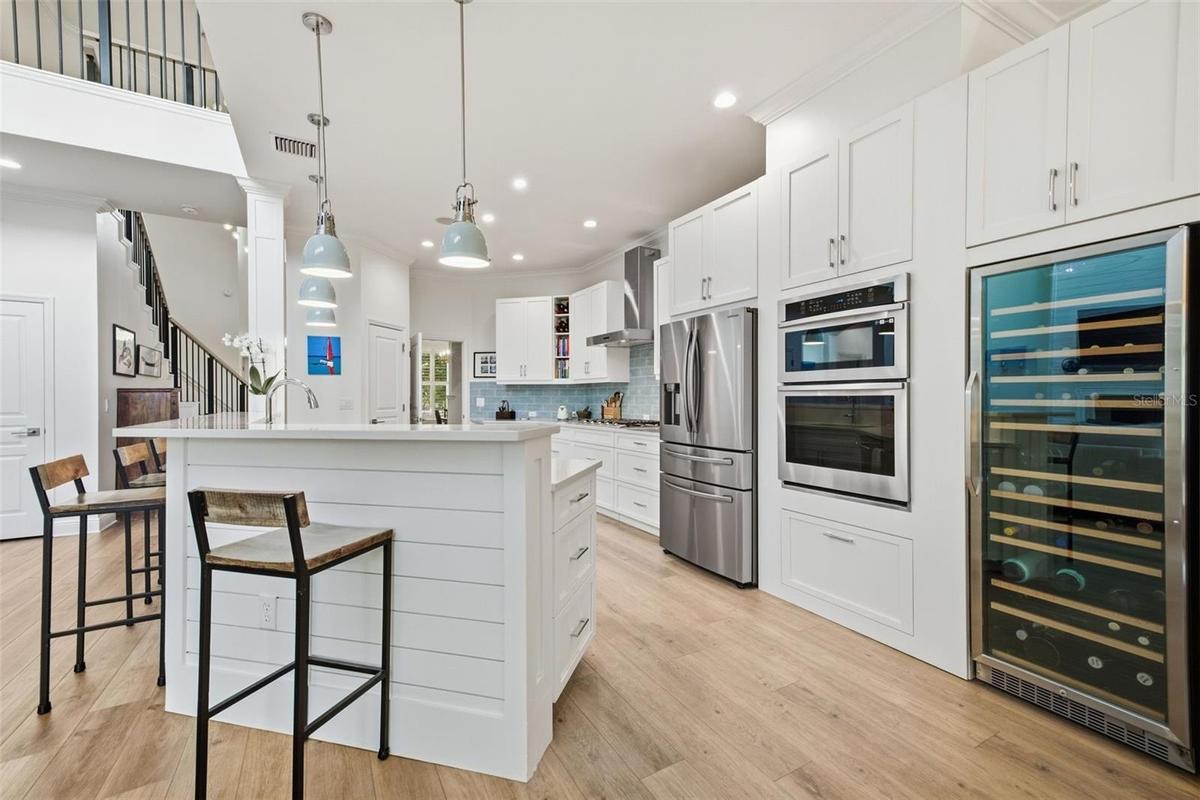 The Kitchen features bar seating, built in appliances, a huge wine fridge and beautiful pendant lighting