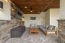 The covered outdoor living area is plumbed for a gas fire pit, and with a wall-mounted TV, it’s ready for fall football and year-round entertaining.