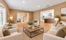Entry to Upstairs and Living Room to Kitchen virtually staged