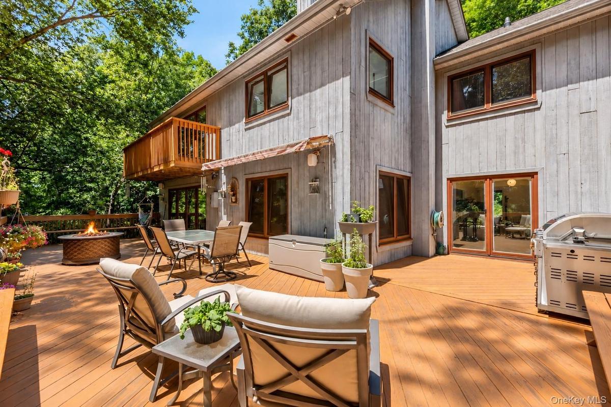 A wraparound deck extends seamlessly from the main-level living space, creating an inviting outdoor extension where thoughtful design and nature beaut