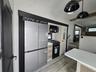 RV: Full-size double-door fridge freezer, full-size gas stove top and oven with microwave above.