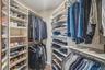 Custom closet organization system with multiple shelving units and hanging rods