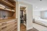 Built-in wood-finish shelving and drawers, walk-in closet with custom organization, crown molding, recessed lighting, and wood-finish flooring
