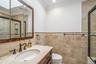 Vanity with integrated sink, dark bronze-finish faucet, and stone countertop